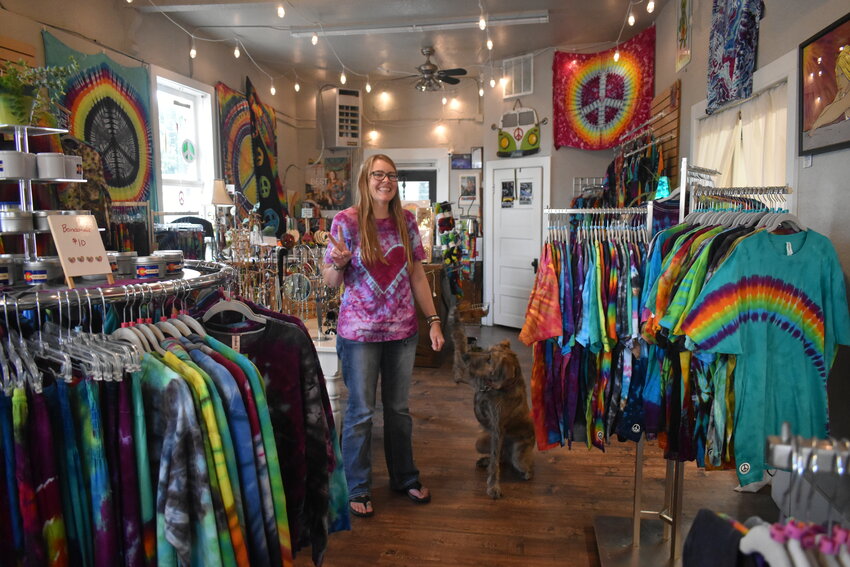 Englewood business owner and tie dye enthusiast Katie DeGroot stands in her shop, the Peace Place with her beloved dog, Vrede on Aug. 23, 2023.